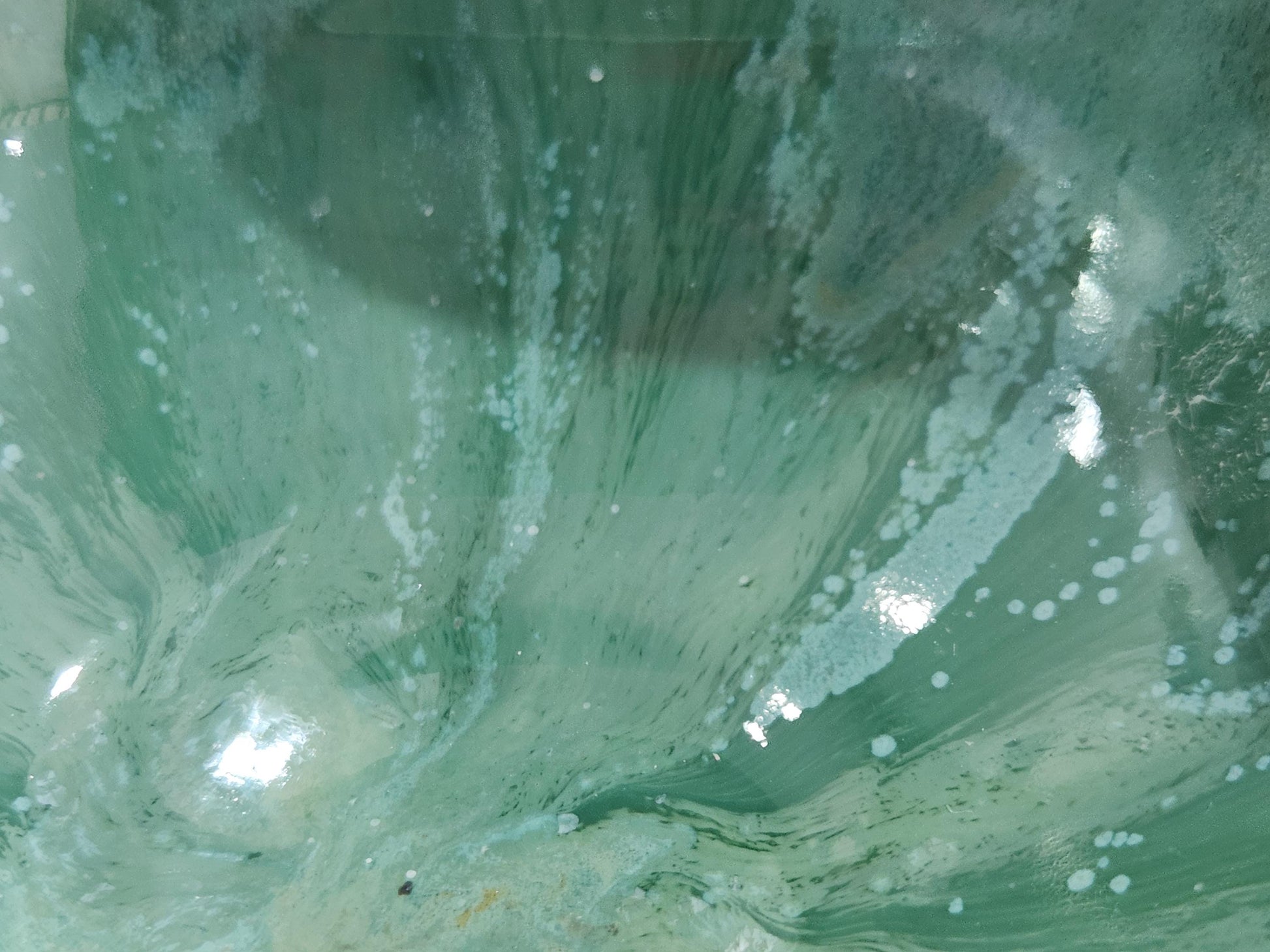 Close up of a Handmade pottery serving bowl with twin compartments, crafted from durable stoneware clay and finished in Buxton Pottery's signature mottled green glaze.