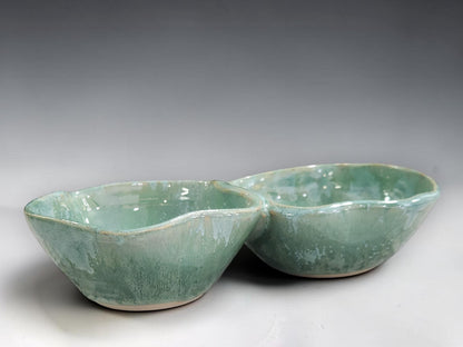 Artisan ceramic divided serving bowl handmade by Buxton Pottery, featuring two connected compartments and unique glaze variations.