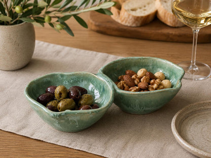 Handmade ceramic double snack bowl by Buxton Pottery, featuring a mottled green glaze and artisan stoneware craftsmanship, styled with olives and nuts in a contemporary entertaining setting.