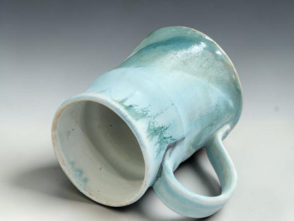 Side view of handmade stoneware mug showing organic wheel-thrown form and comfortable handle