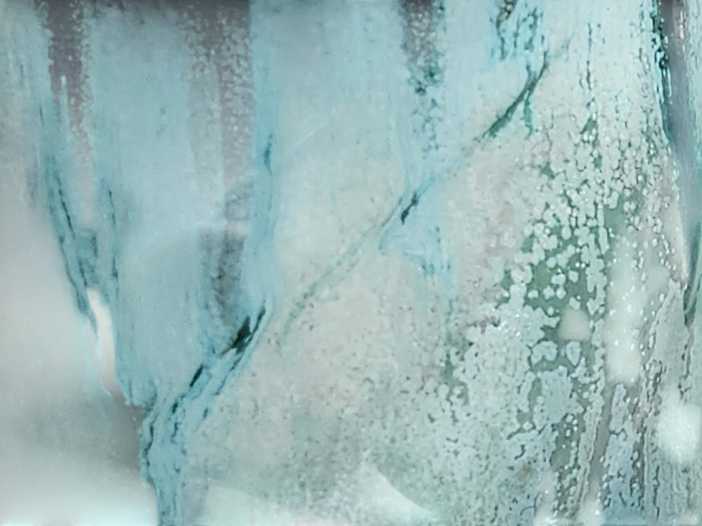 Detail of layered blue-green glaze with natural flowing patterns on handmade ceramic mug