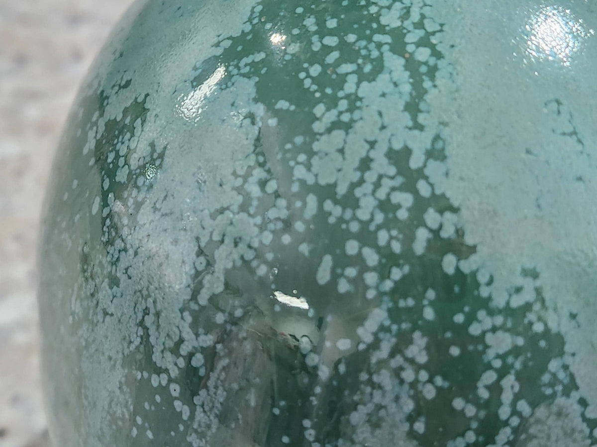 Close-up of organic mottled green glaze on handmade stoneware salt pig