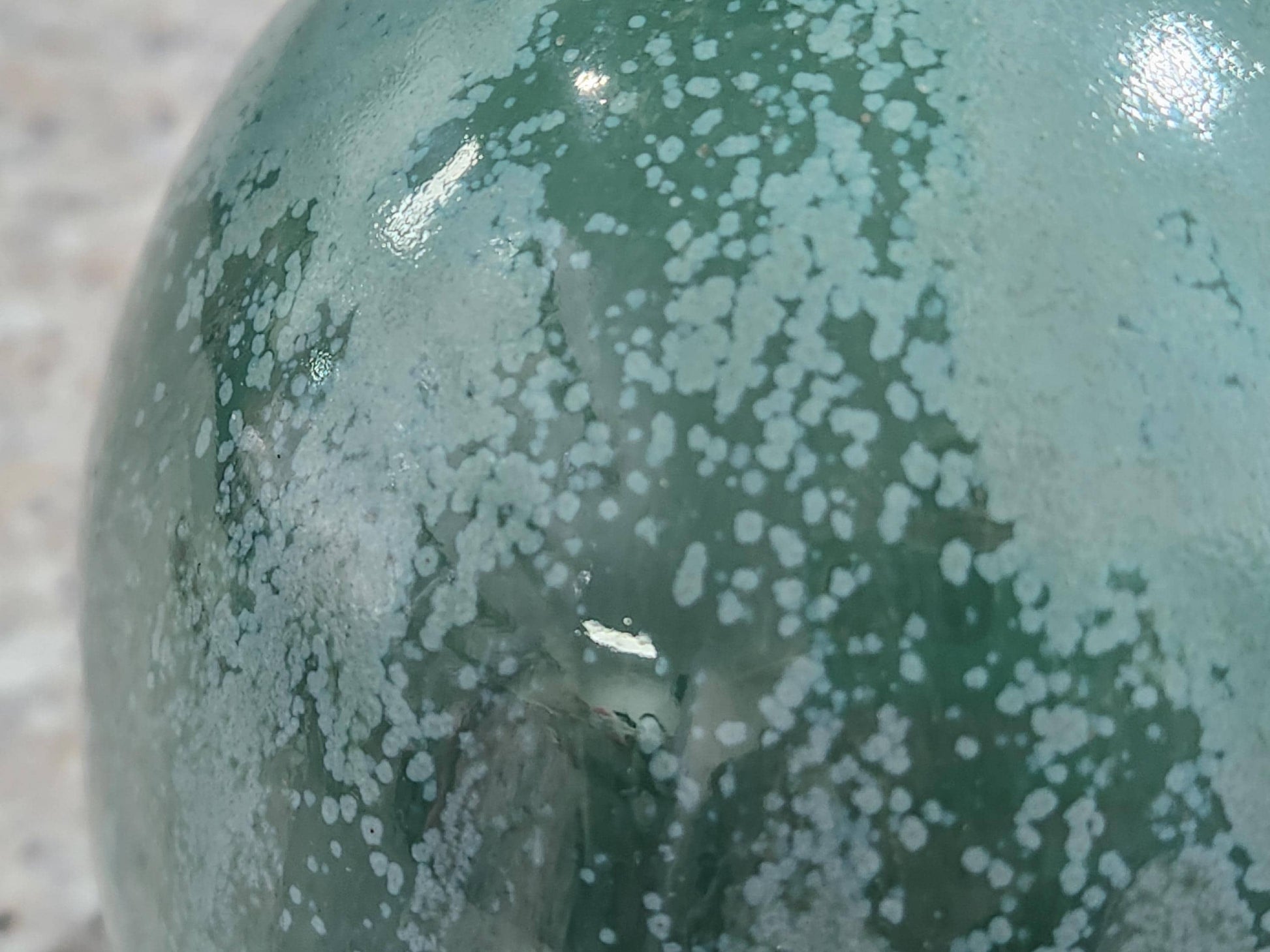 Close-up of organic mottled green glaze on handmade stoneware salt pig