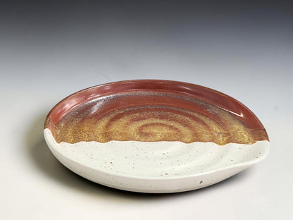 Rustic pottery spoon rest with speckled cream and warm brown glaze