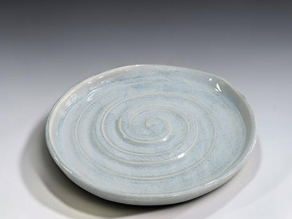 Handmade pottery utensil rest with spiral pattern and gently raised rim
