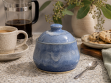 Handmade blue ceramic sugar bowl with matching lid in a kitchen lifestyle setting