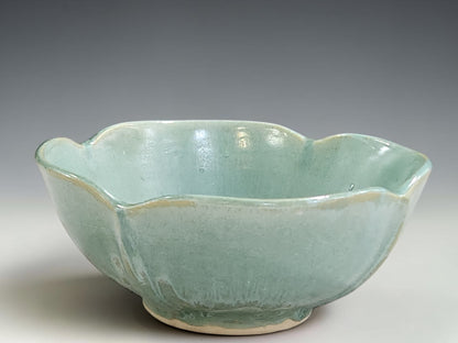Handmade pottery bowl with organic altered rim and soft glossy green glaze