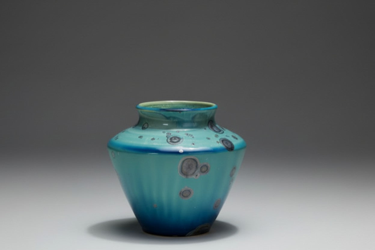 Small handmade ceramic vase side view, semi-matte glaze with metallic crystalline spots