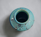 Top view into small handmade bud vase opening, blue-green glaze with crystal details