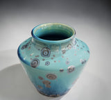 Small handmade ceramic vase side view, semi-matte glaze with metallic crystalline spots from the side top.