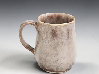 Tall neutral-toned ceramic mug with softly rounded base