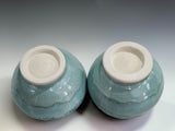 Handmade stoneware teacups in a calming tea ceremony-inspired setting, featuring Buxton Pottery's signature mottled green glaze and contemporary artisan design.