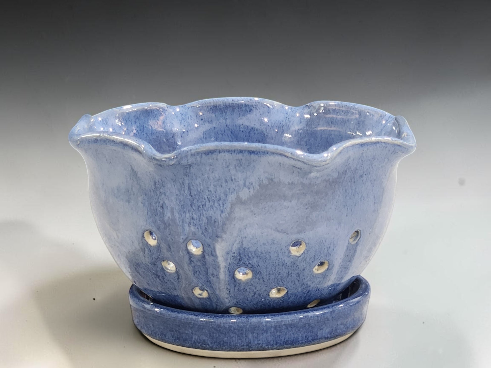 Decorative handmade stoneware berry bowl with wavy rim and drainage holes