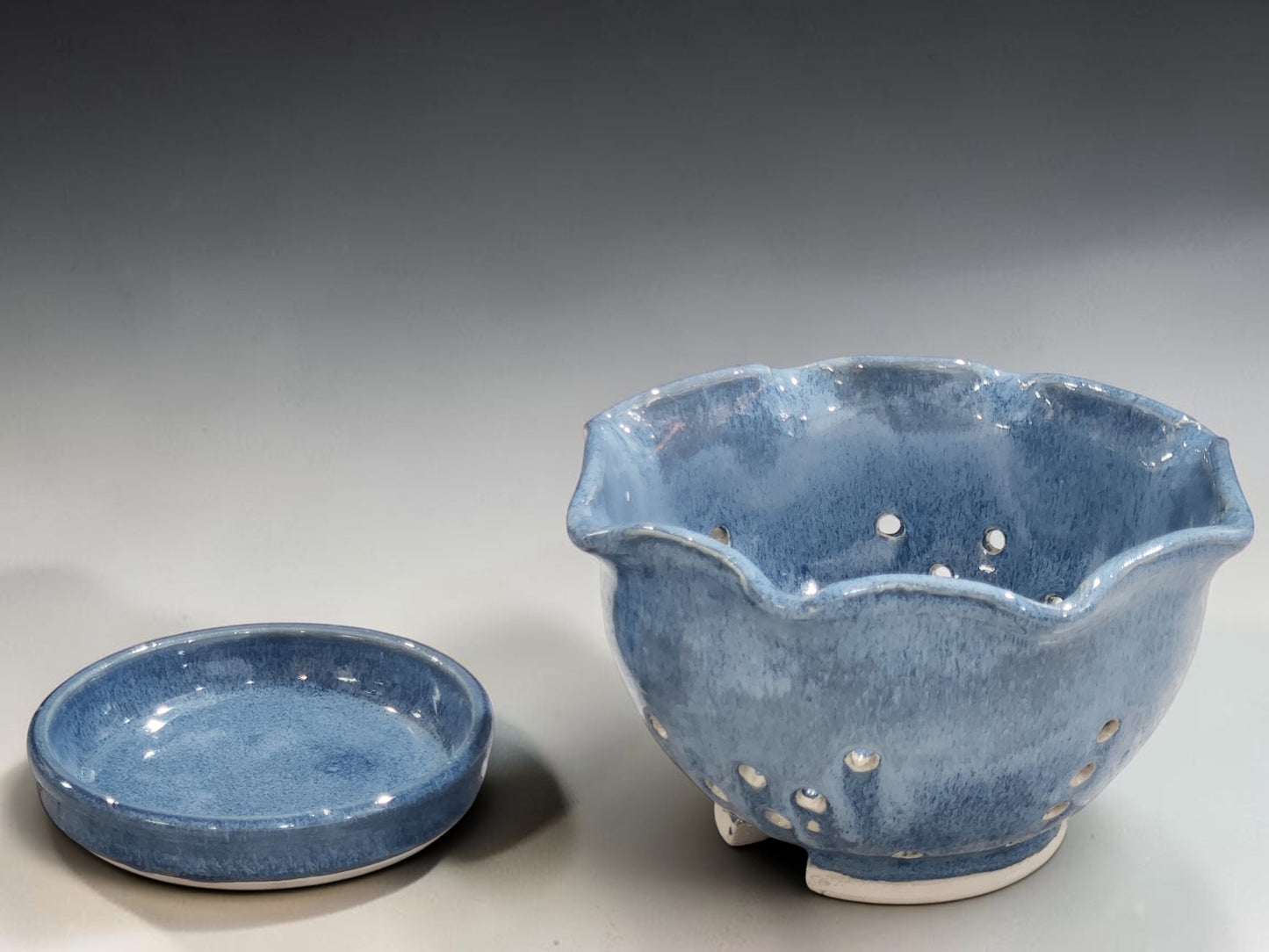Handmade pottery berry colander in mottled blue glaze with scalloped rim