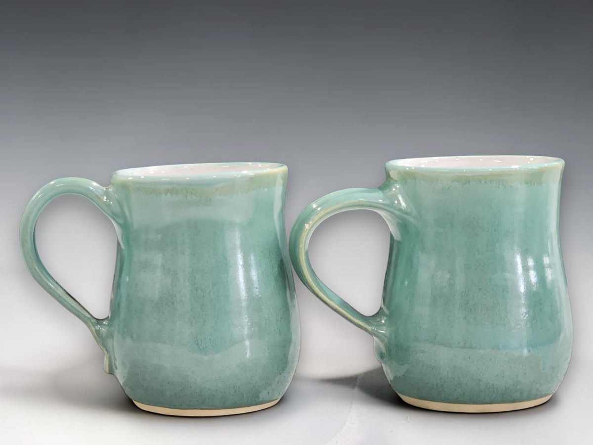 Handmade stoneware mug with mottled green glaze and white interior, crafted by Buxton Pottery for coffee, tea and everyday use.