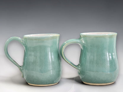 Handmade stoneware mug with mottled green glaze and white interior, crafted by Buxton Pottery for coffee, tea and everyday use.