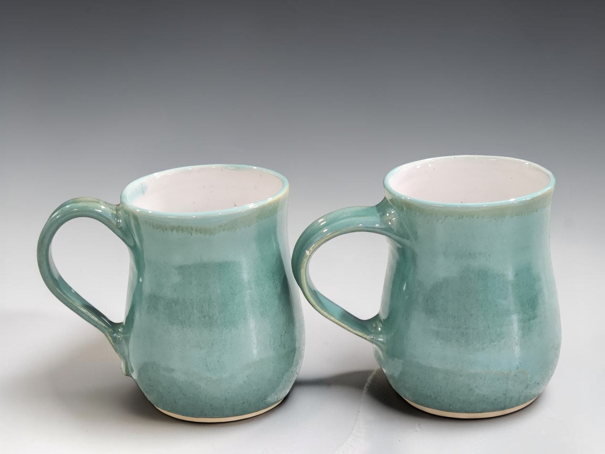 Artisan ceramic coffee mug handmade in Melbourne, featuring layered green glazes that create unique variations on every piece.