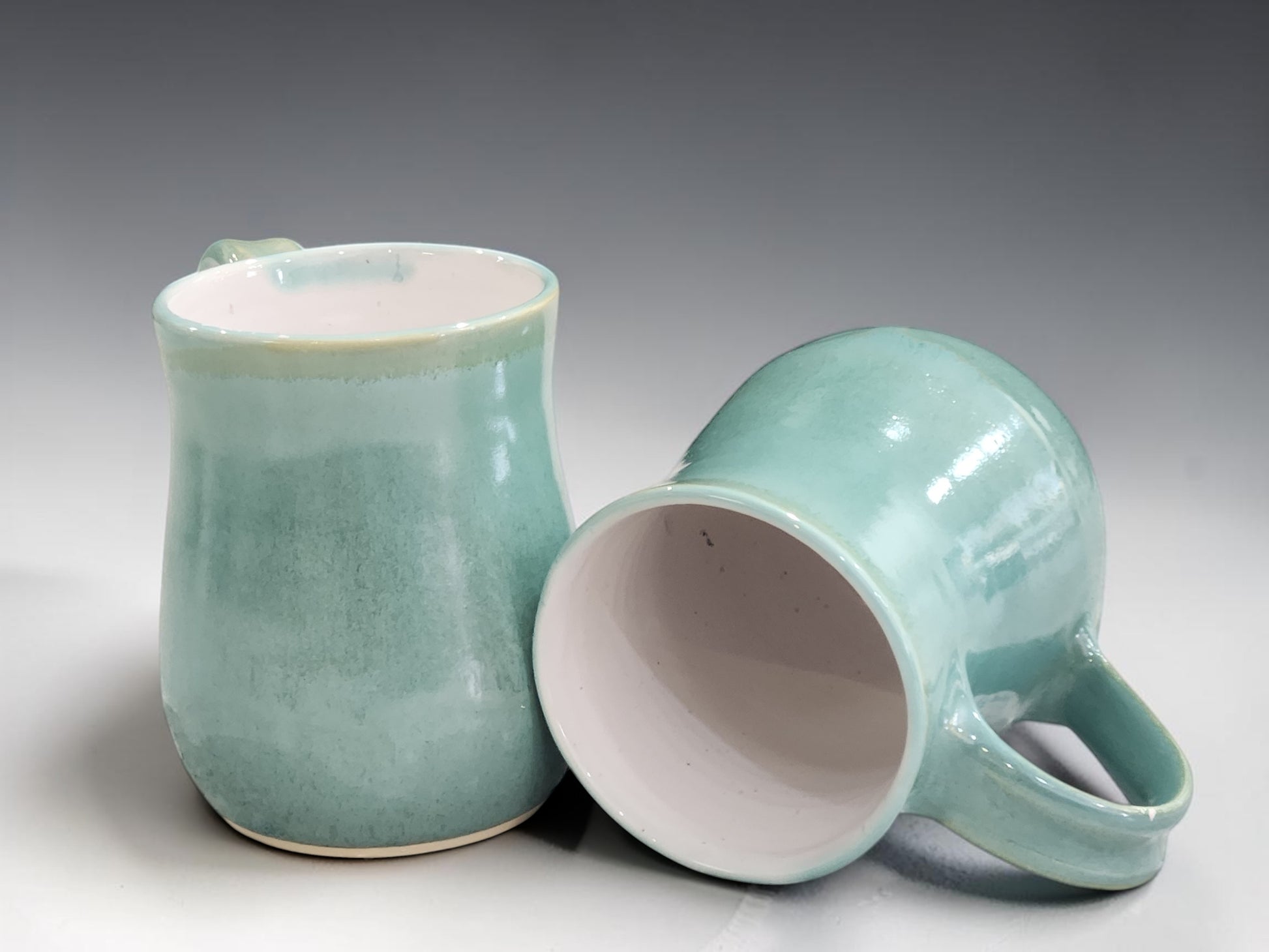 Australian handmade pottery mug with mottled green stoneware finish, combining functional design with timeless ceramic artistry.