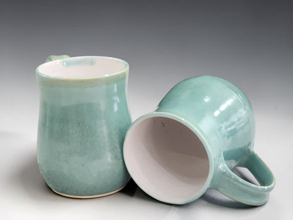 Australian handmade pottery mug with mottled green stoneware finish, combining functional design with timeless ceramic artistry.