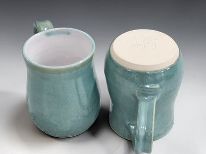 Handcrafted ceramic coffee cup with white glazed interior and organic green exterior, made in Melbourne using traditional pottery techniques.