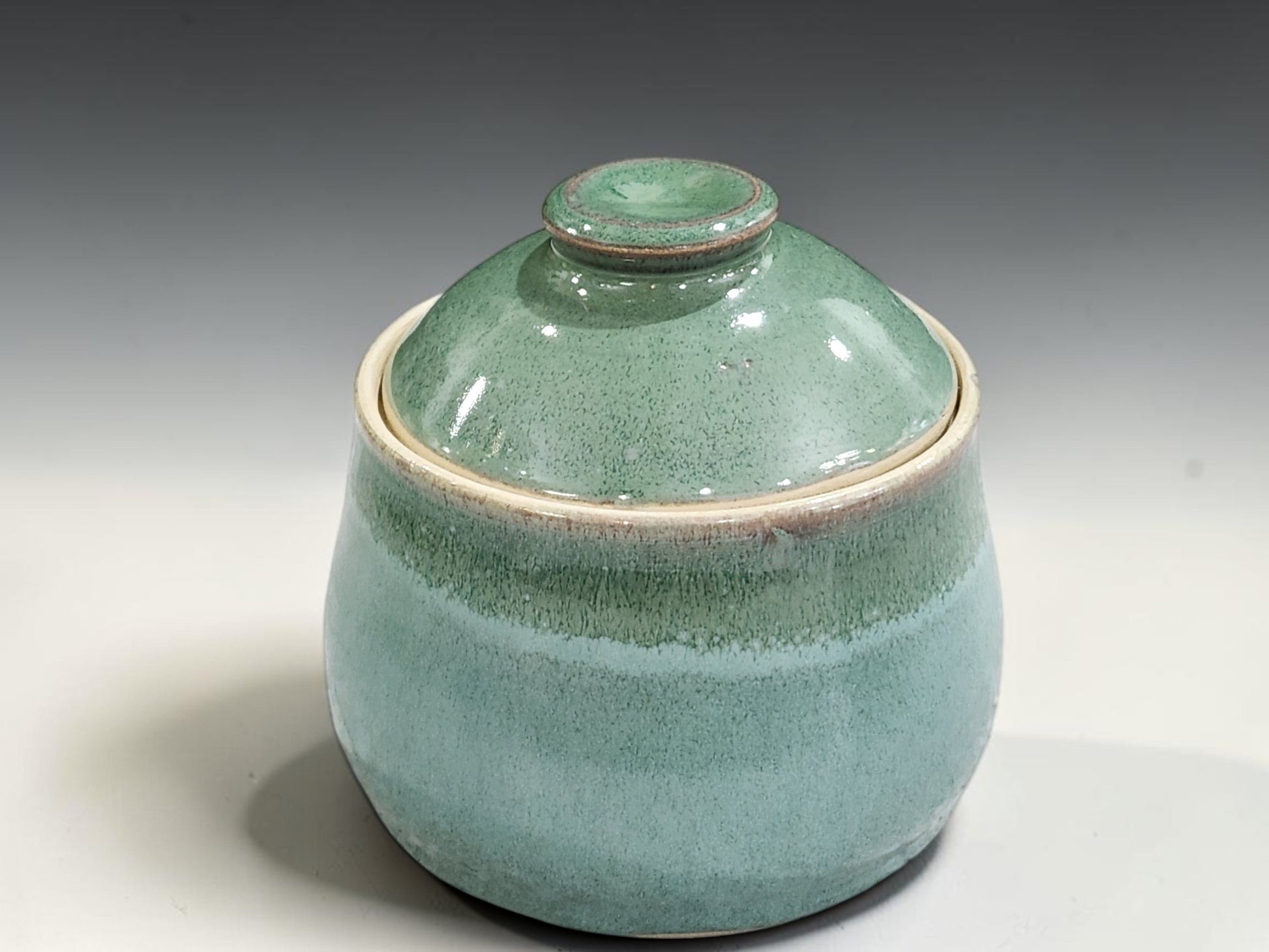 Ceramic lidded sugar bowl in soft green and cream glaze