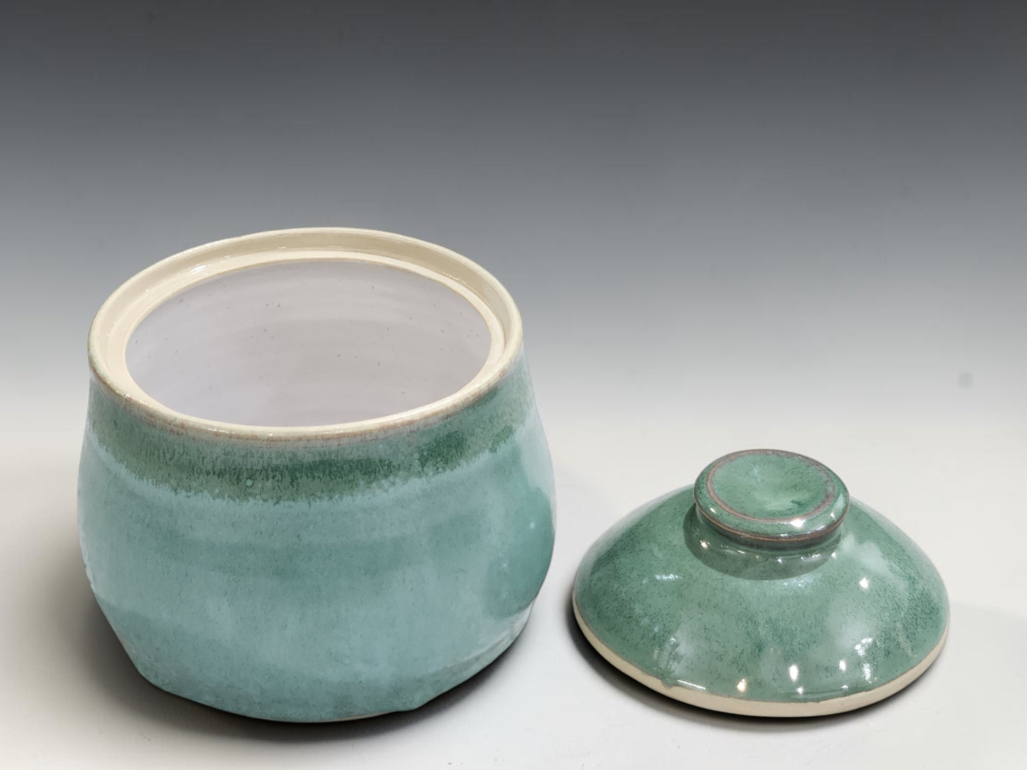 Small green stoneware storage bowl with matching ceramic lid
