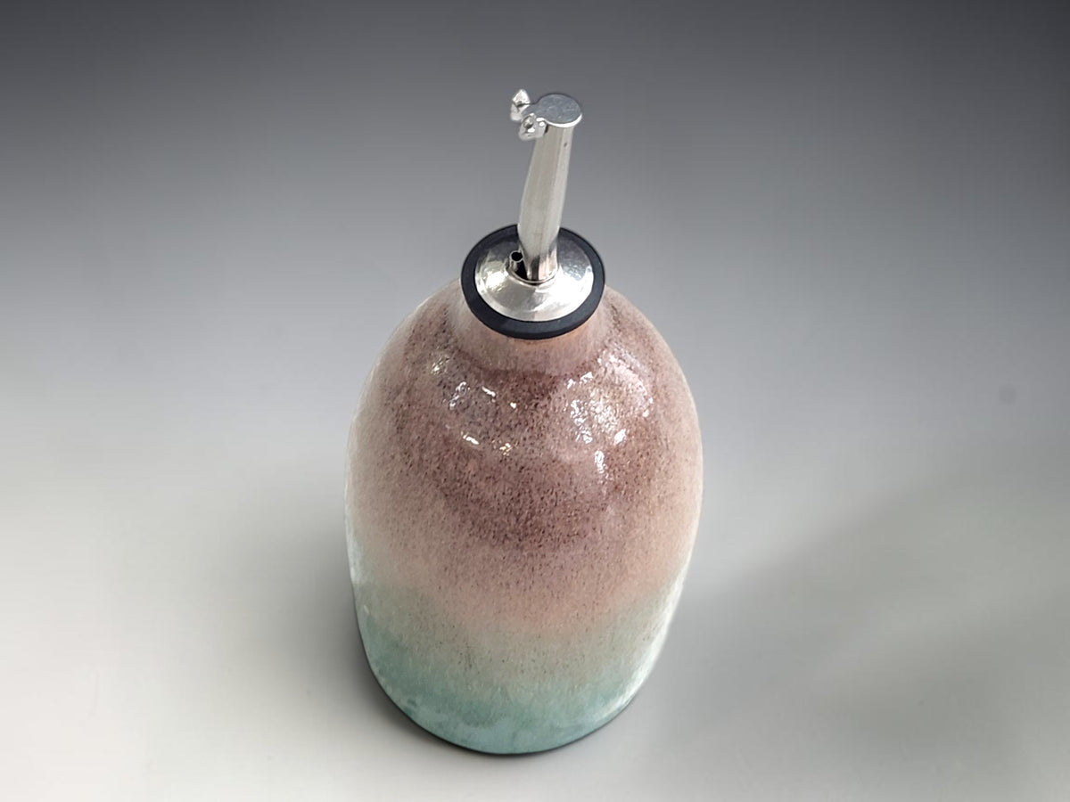 Top view of a handmade oil bottle with a stainless steel pourer from Buxton Pottery