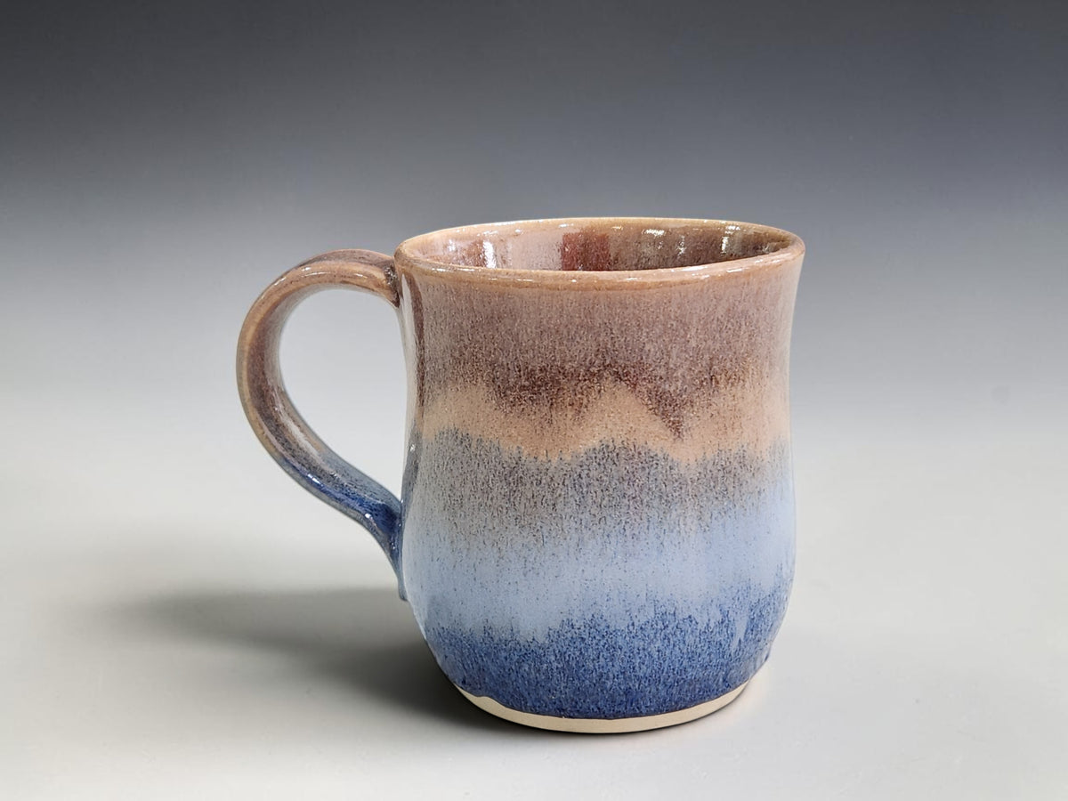 Handmade 300 ml stoneware mug with layered blue oatmeal and warm brown glaze