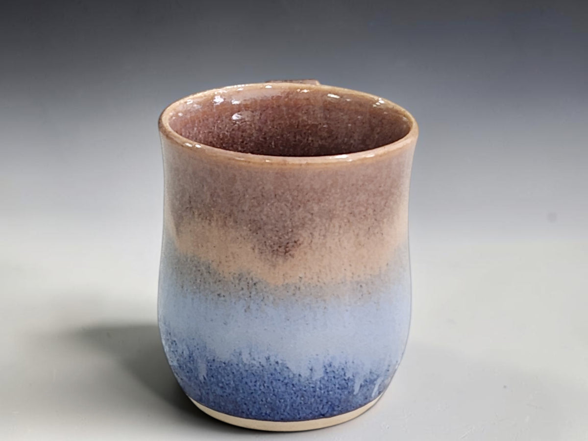 Side view of handmade stoneware mug and curved pottery handle