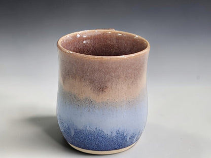 Side view of handmade stoneware mug and curved pottery handle