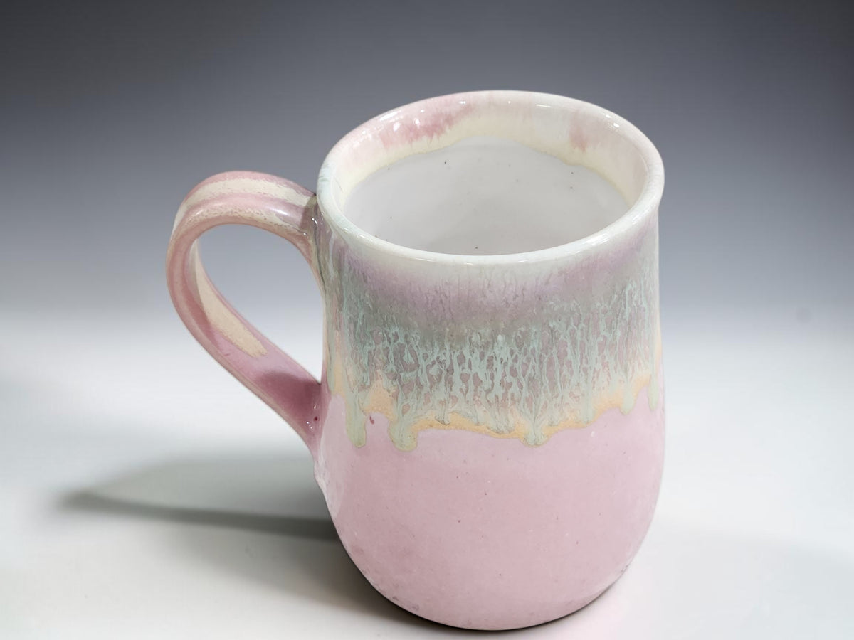 Handmade pottery mug in soft pink with layered green and cream glaze, Melbourne Australia