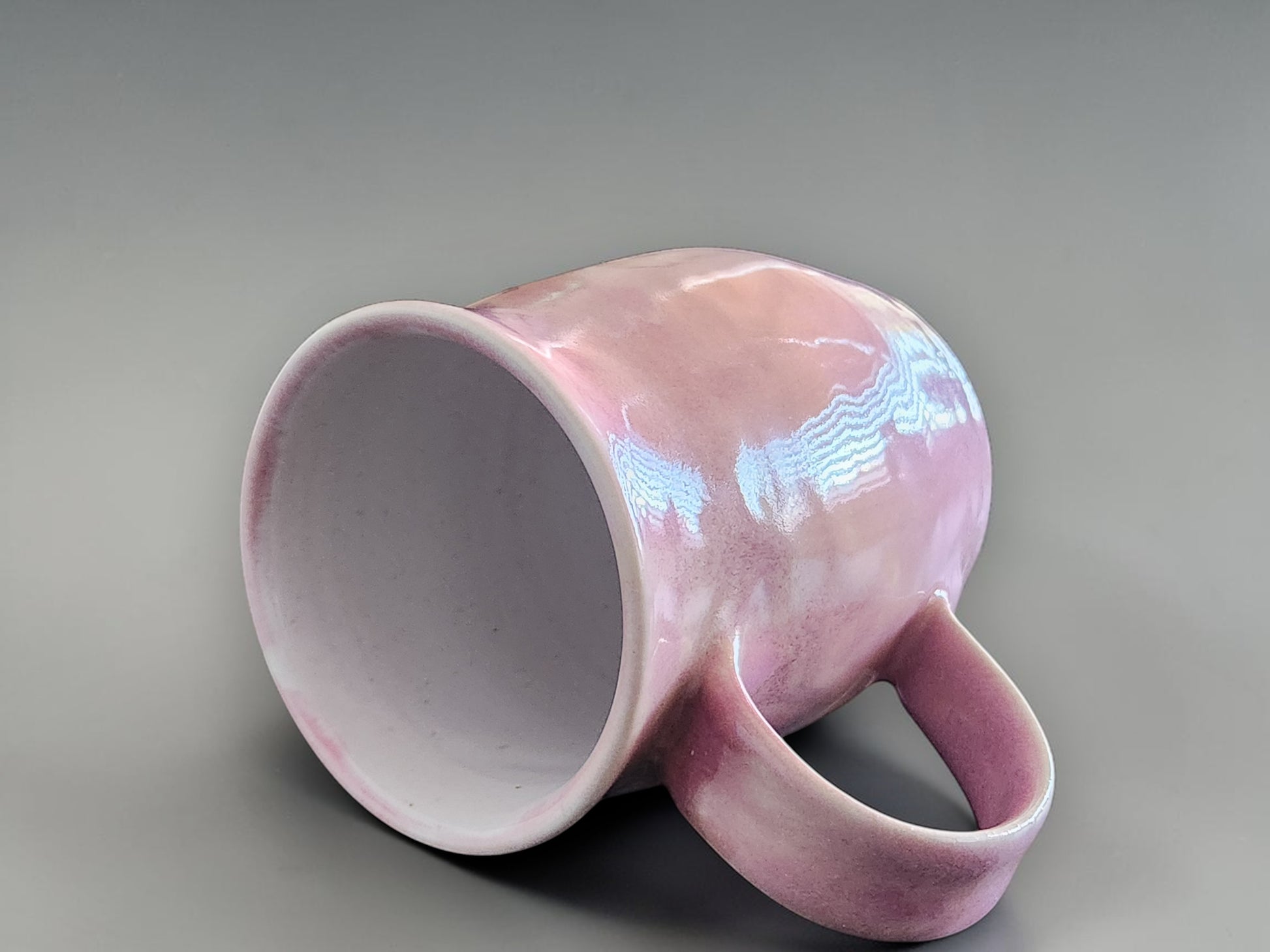 Handmade pink pottery mug with curved handle