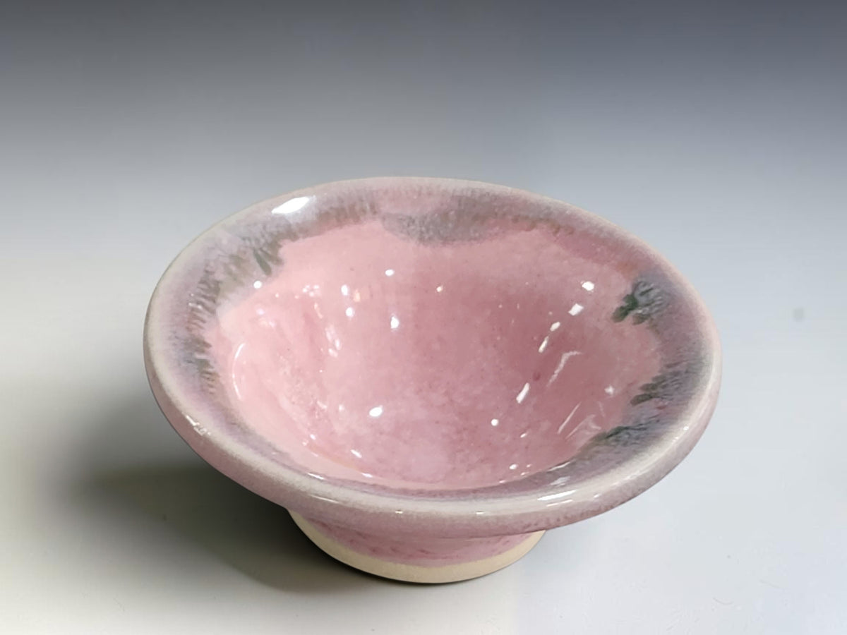 Pink ceramic trinket bowl with gently flared sides and a cream unglazed foot.