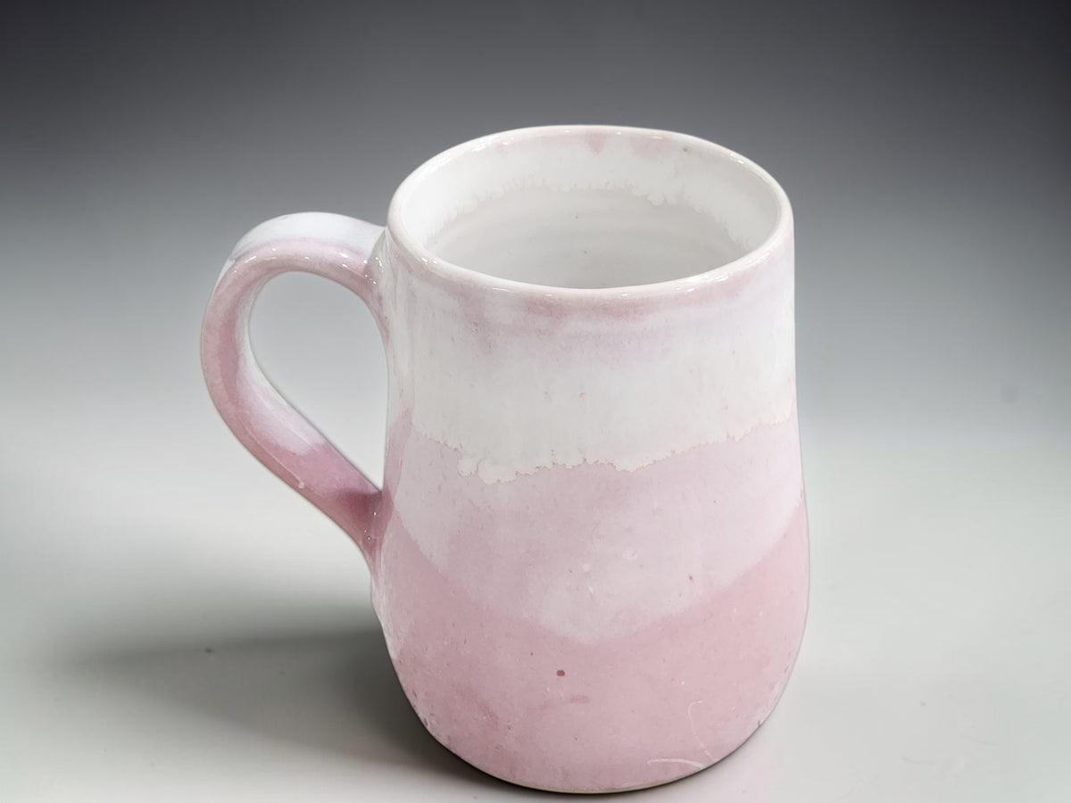 Pink pottery mug second with small area of incomplete glaze coverage