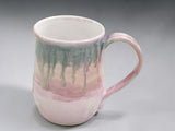 Handmade pink and green ceramic mug with flowing glaze detail