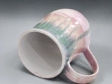 Tall handmade ceramic mug with pink base and green glaze detail