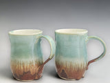 Tall ceramic mug with soft green and earthy brown glaze