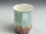 Artisan ceramic mug in green and warm brown tones
