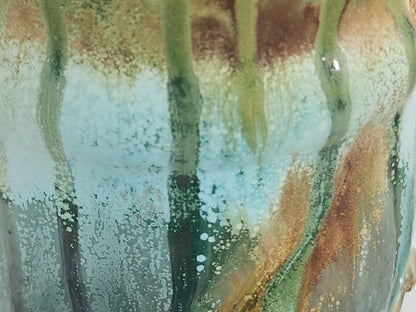 Close-up of Bush Creek Earth handmade pottery mug showing flowing aqua, sage and earthy brown glaze detail