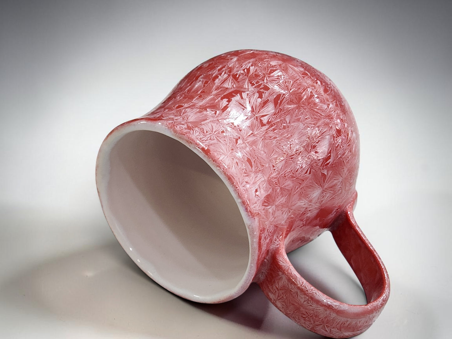 Australian studio pottery mug with red and pale crystal glaze