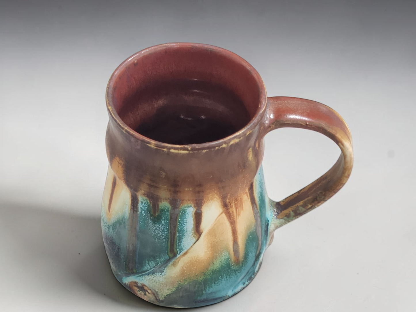 Interior view of handmade stoneware mug with warm terracotta glazed interior