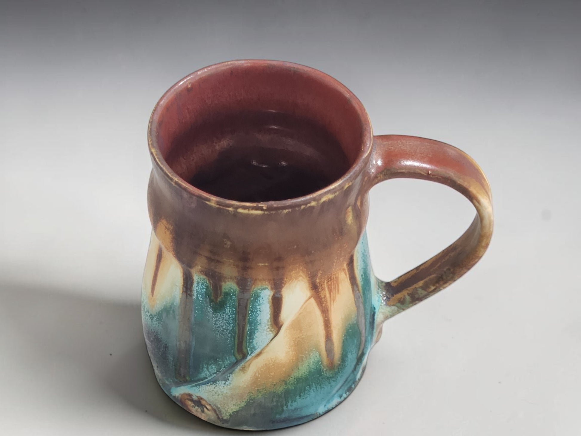 Interior view of handmade stoneware mug with warm terracotta glazed interior