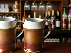 Handmade ceramic beer stein with speckled cream and red-brown glaze