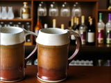 Handmade ceramic beer stein with speckled cream and red-brown glaze