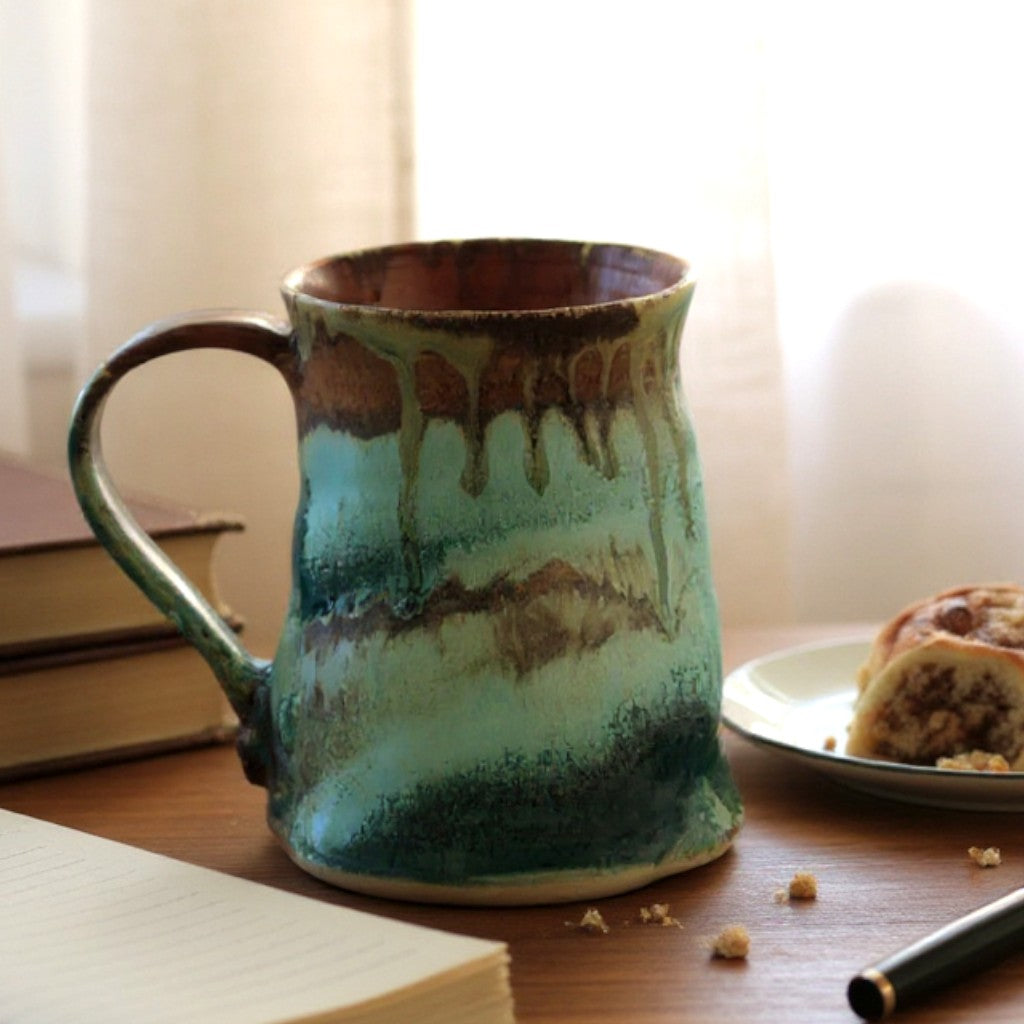 Handmade ceramic mug with green and rust glazes
