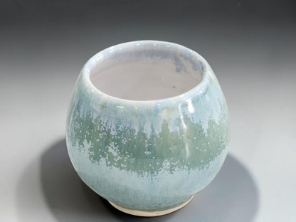 Front view of rounded green ceramic tea and whisky cup