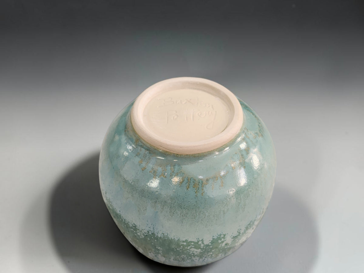 underside of soft green speckled glaze on handmade handleless tea cup