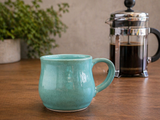 Handmade green ceramic cup in lifestyle kitchen setting