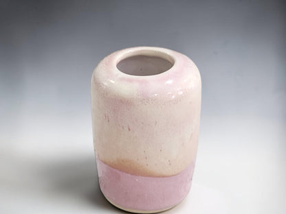 Petite ceramic flower vase with a rounded form and small circular opening