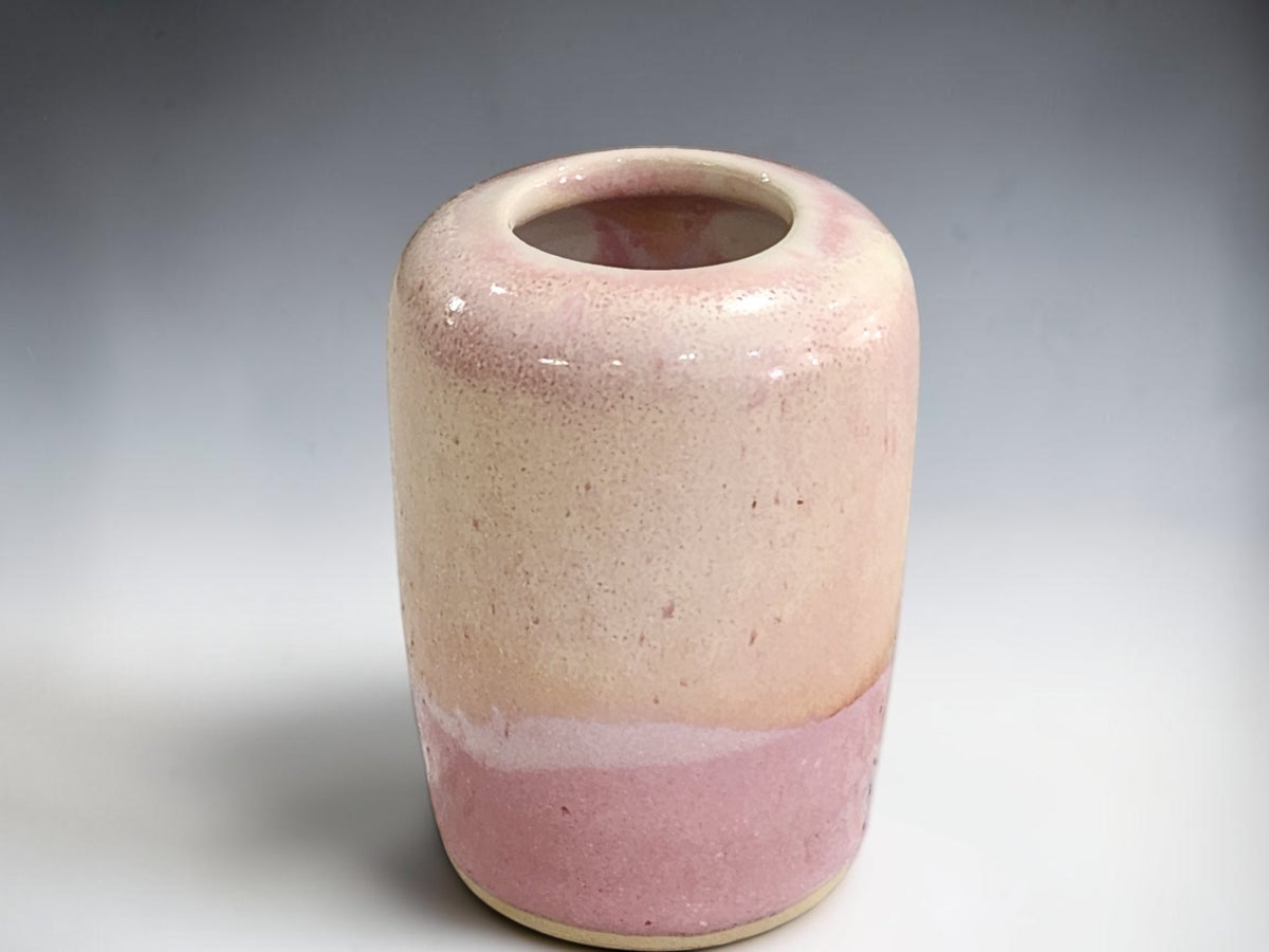 Dusty-pink ceramic bud vase shown from the front